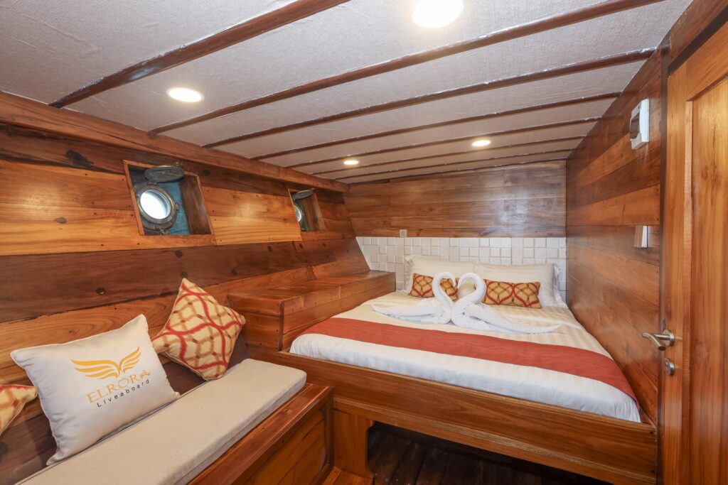 Elrora standard cabin bed with swan towel art and a cushioned bench
