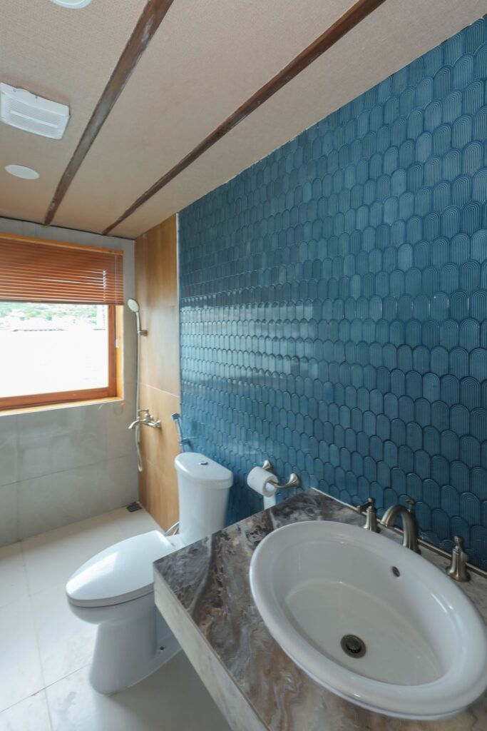 Owners suite ensuite bathroom with blue scalloped wall tiles and a vanity