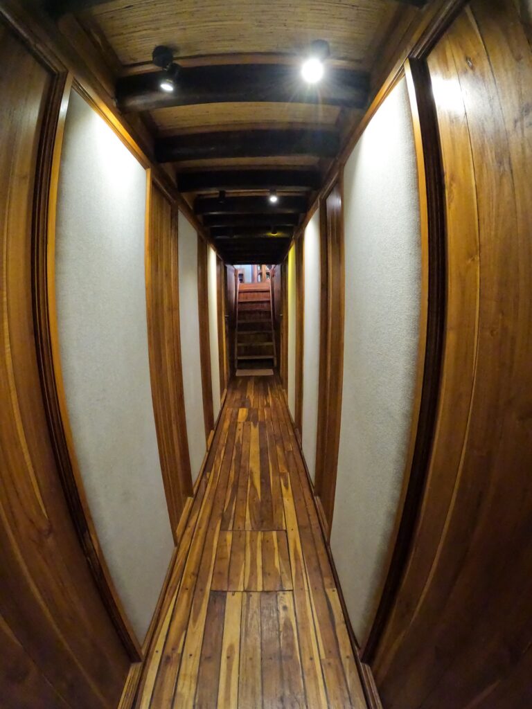 Wooden interior hallway lined with cabin doors aboard the Gammara