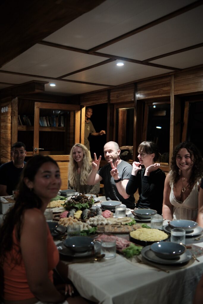 Guests seated together for an evening dinner indoors aboard the Gammara