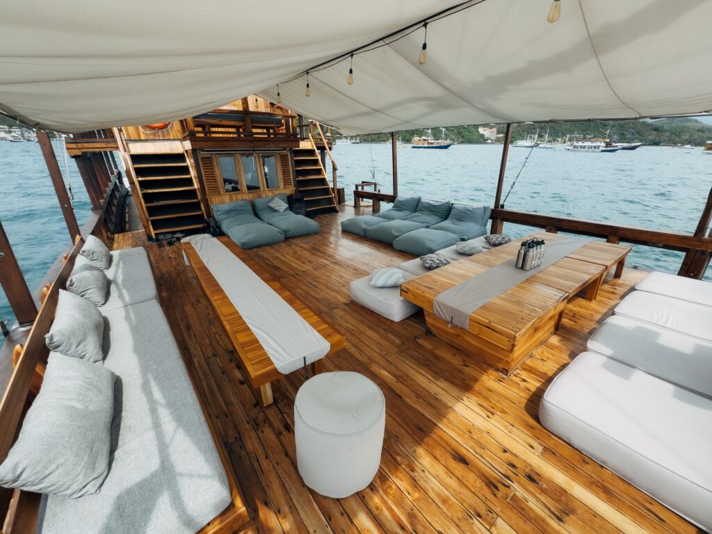 Shaded main deck lounge on the Gammara with cushioned benches and string lights
