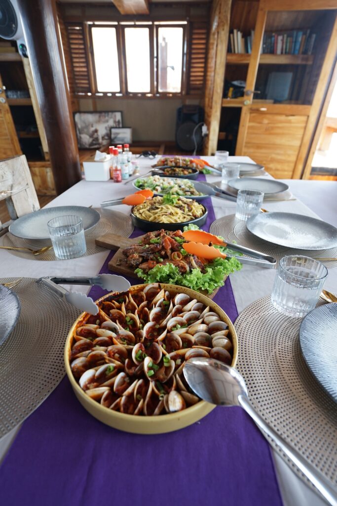 Indoor dining table set with salads and sliced dishes for lunch