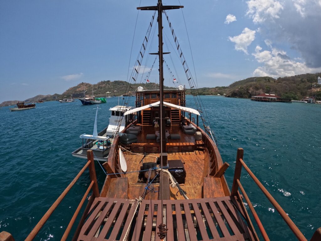 View forward from the Gammara bow deck toward anchored boats and hills