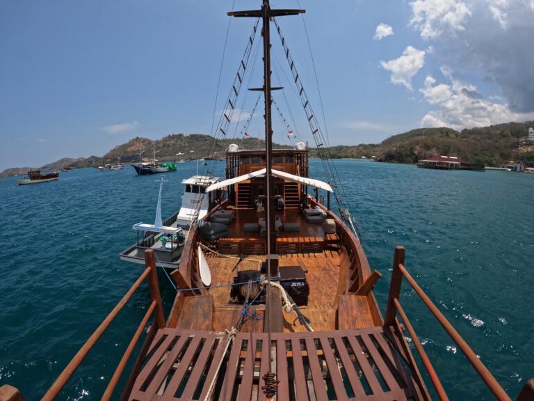 View forward from the Gammara bow deck toward anchored boats and hills