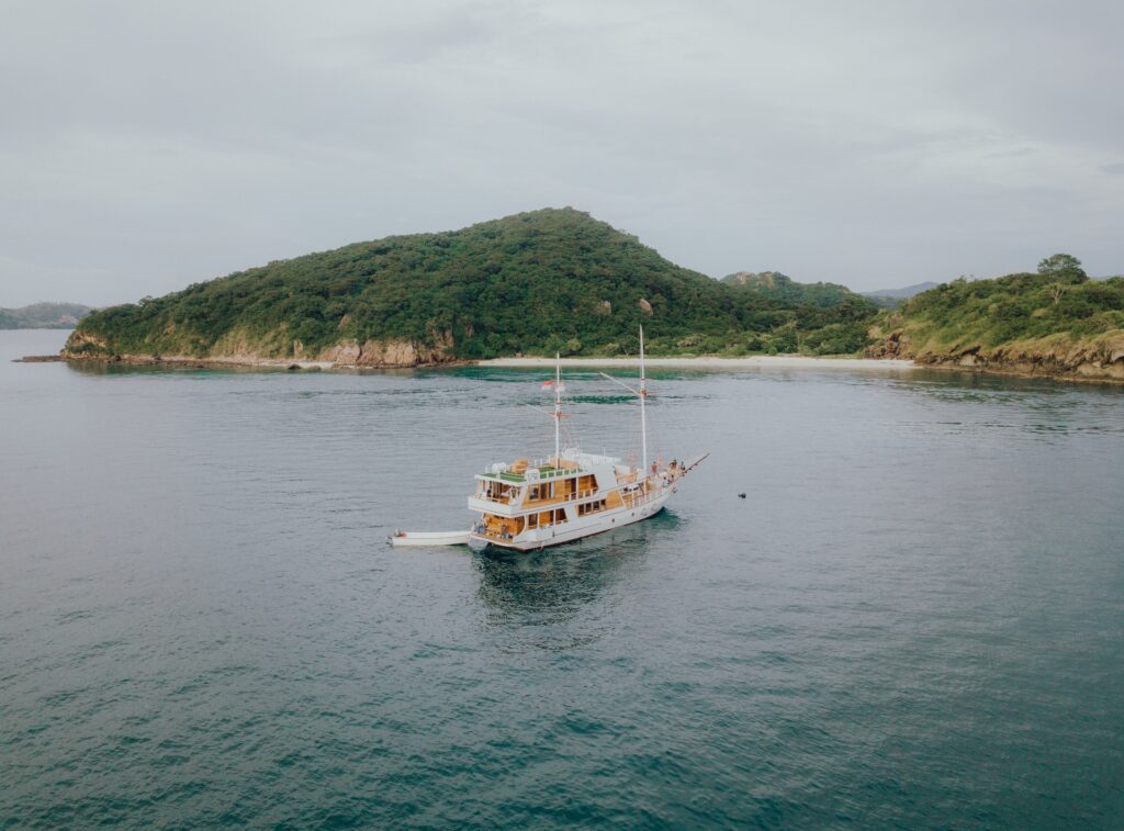 The Gandiva anchored along a steep green coastline near Bidadari Island