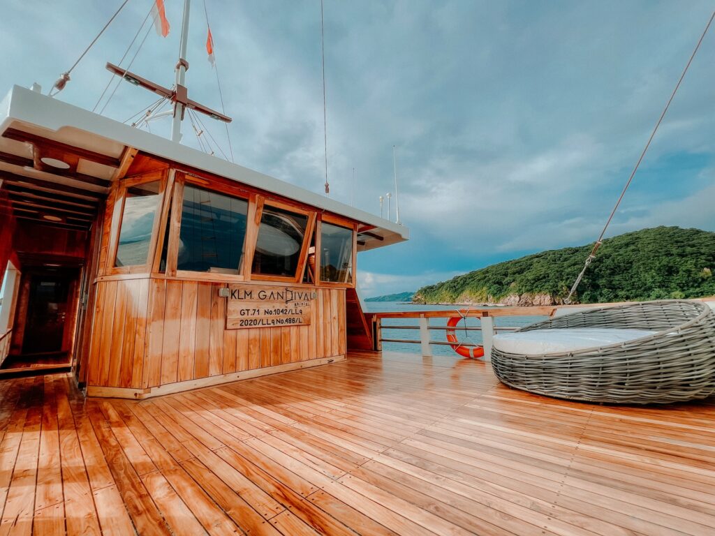 Upper deck lounge on the Gandiva with a round rattan daybed near the wheelhouse