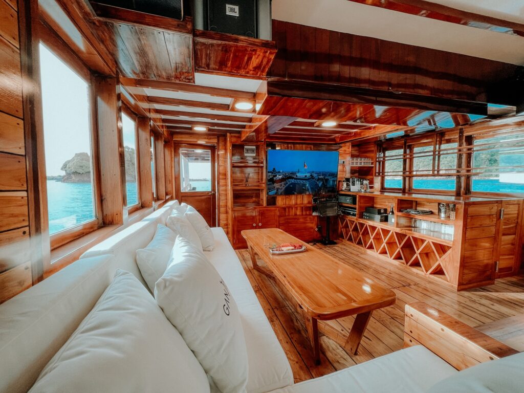 Main salon interior on the Gandiva with white sofas and a wooden coffee table