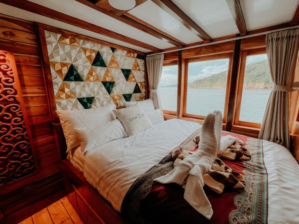 Cabin aboard the Gandiva with a triangle-patterned headboard and ocean-view windows