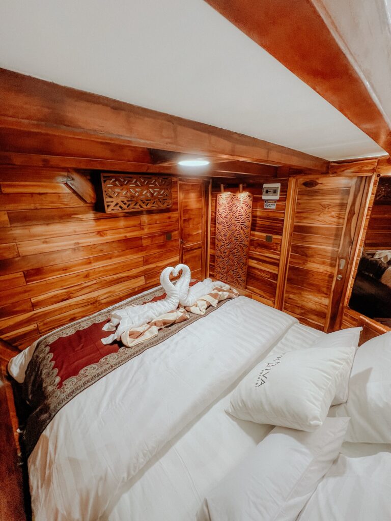 Cabin bed with swan towel art and a small woven wall hanging