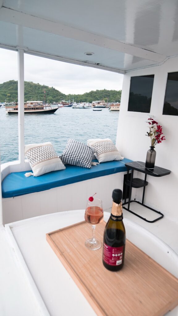 Blue cushioned bench seating with sparkling wine over the Labuan Bajo harbor