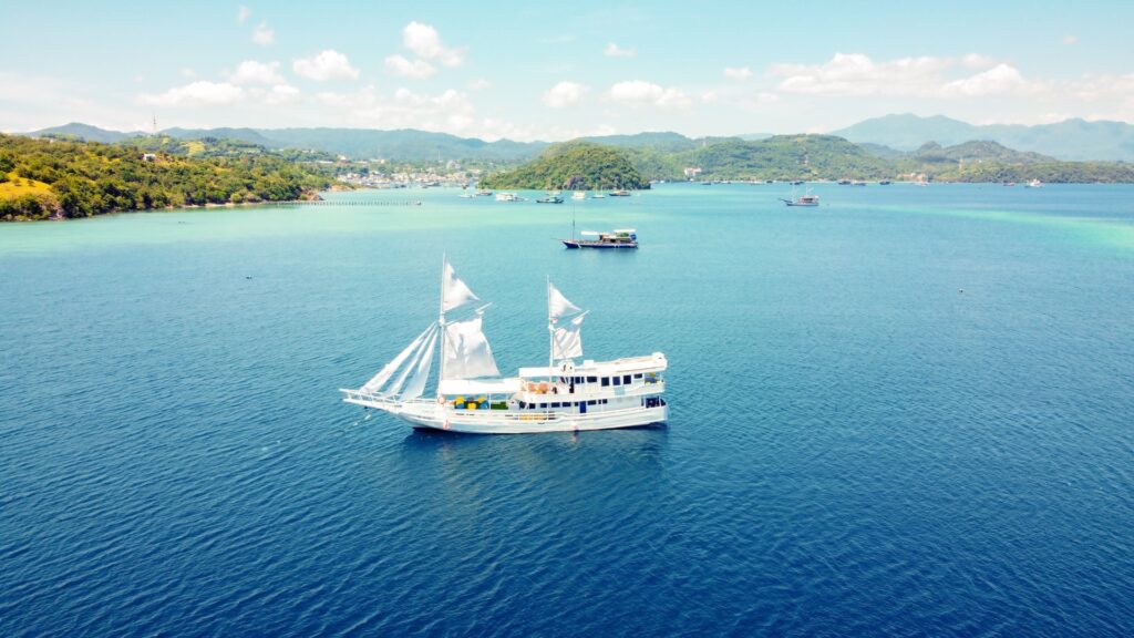 Giona liveaboard anchored near Kelor Island in deep blue water