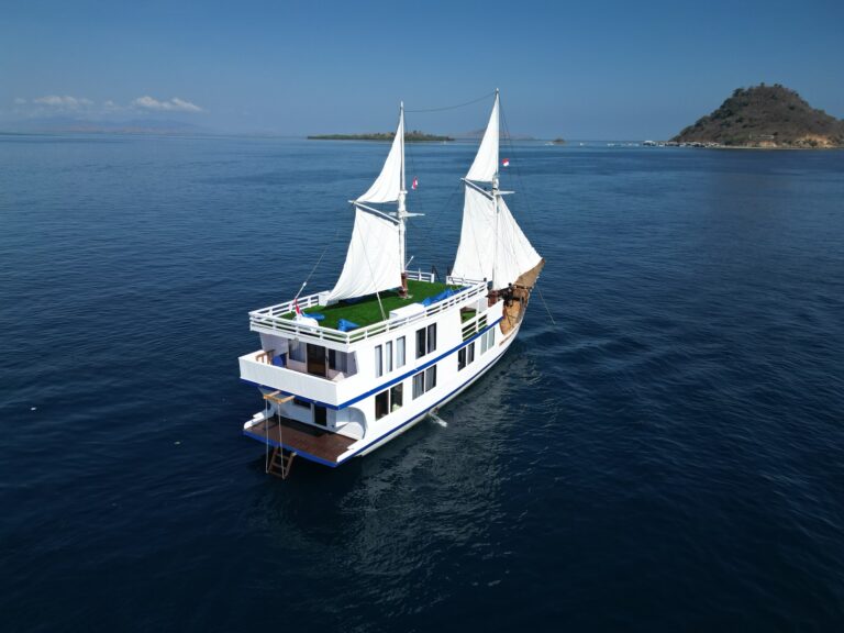 Aerial view of the Invictus under full sail near a small island