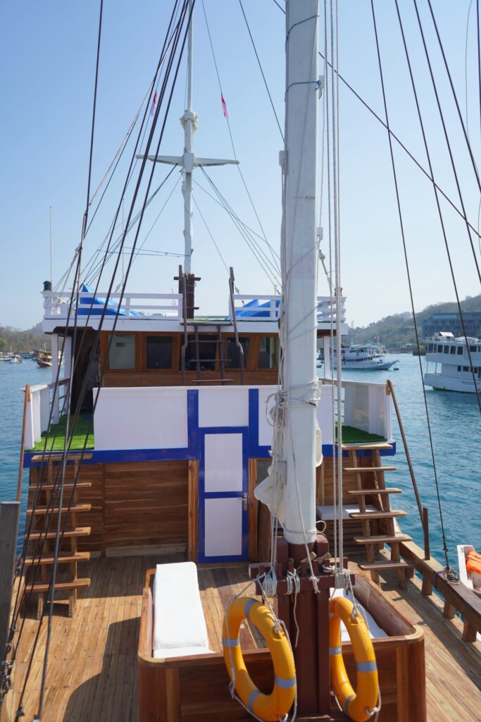 Invictus komodo liveaboard main deck stairs with blue and white trim over the harbor