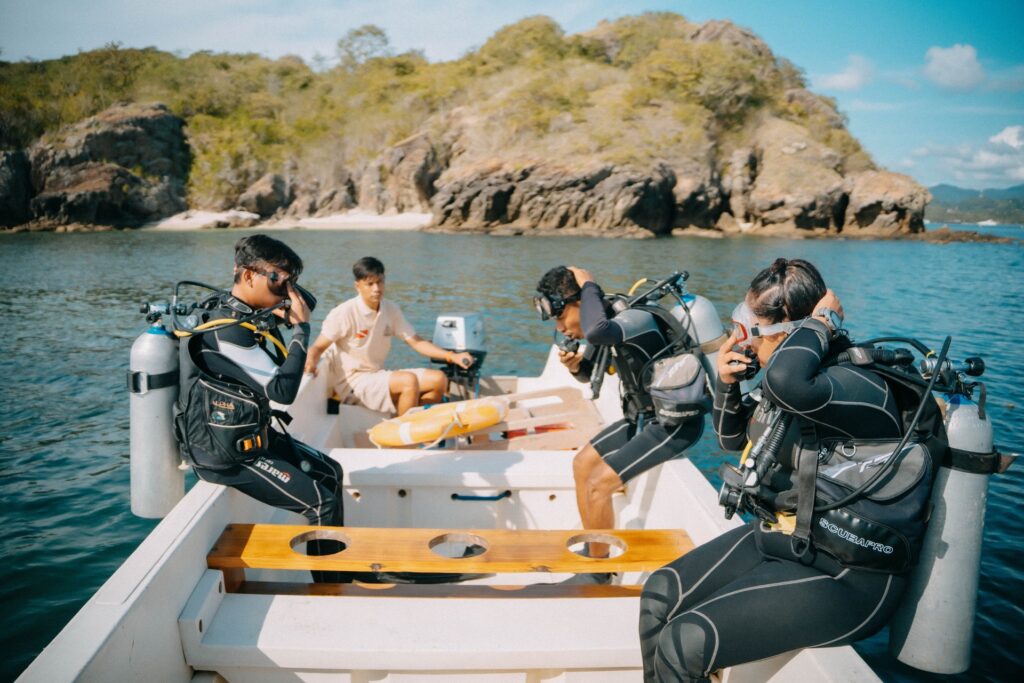Divers gearing up on a tender near a rocky bay at Tatawa