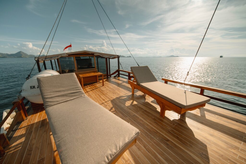 Two wooden sun loungers on deck facing the horizon near Padar Island