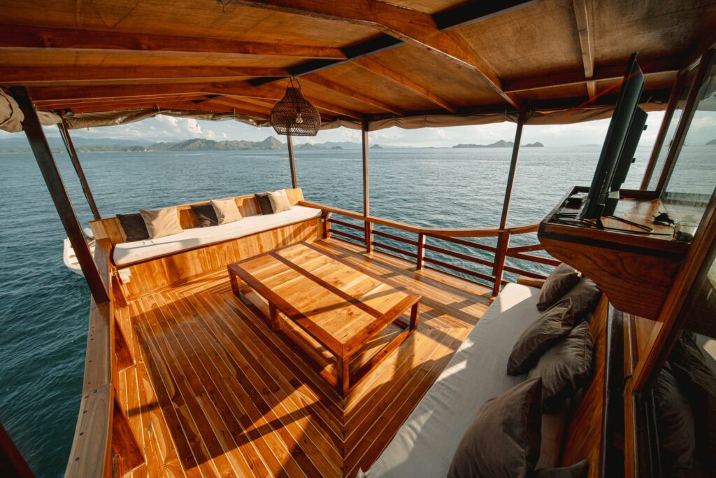 Shaded aft lounge with wraparound cushioned seating and a wooden coffee table