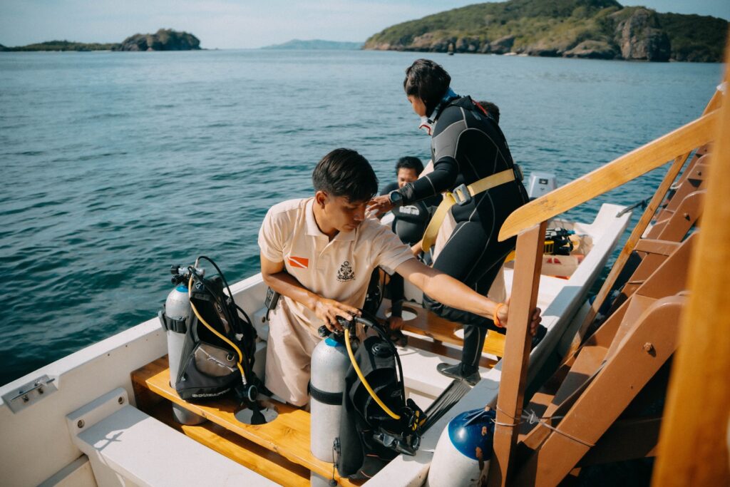 Crew preparing scuba tanks and BCDs on deck before a dive