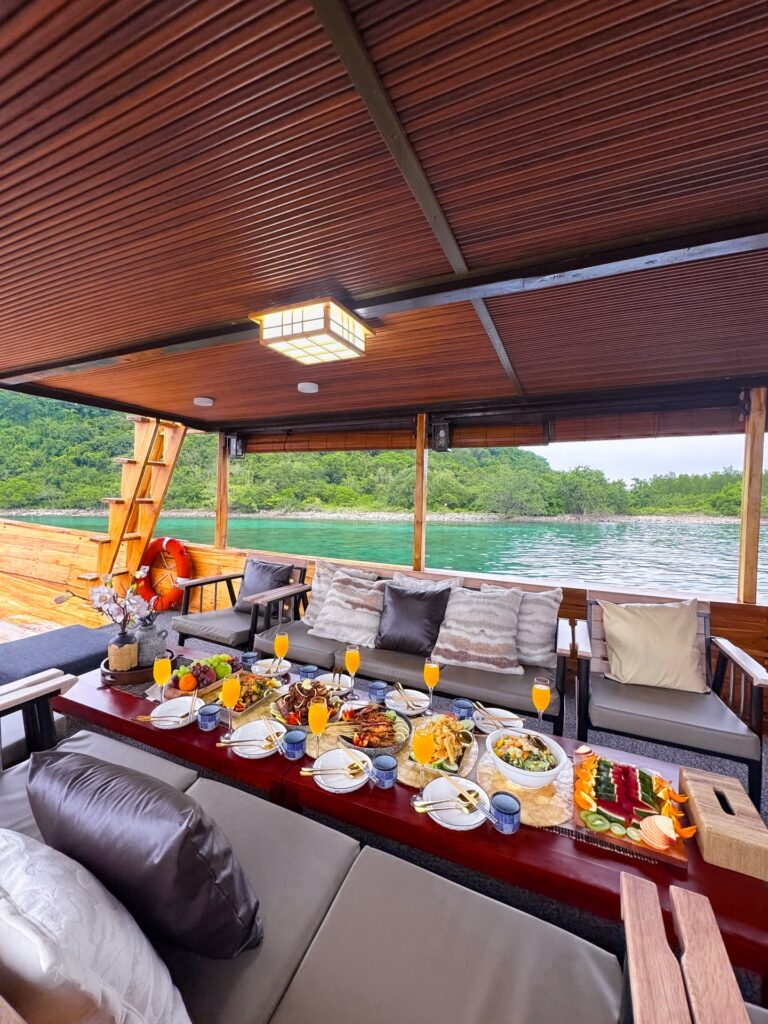 Deck lunch spread set on a long low table beneath a canopy