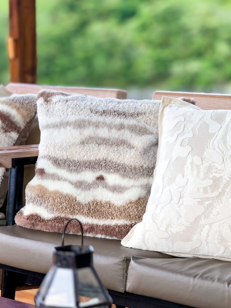 Close-up of textured striped and lace-patterned throw pillows on deck seating