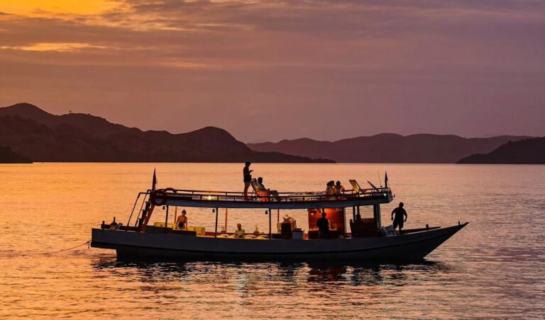 Silhouette of the Kimochi boat and guests cruising at sunset