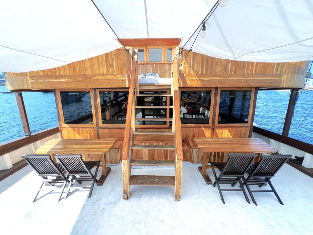 Outdoor lounge with deck chairs and wooden stairs beneath a canopy
