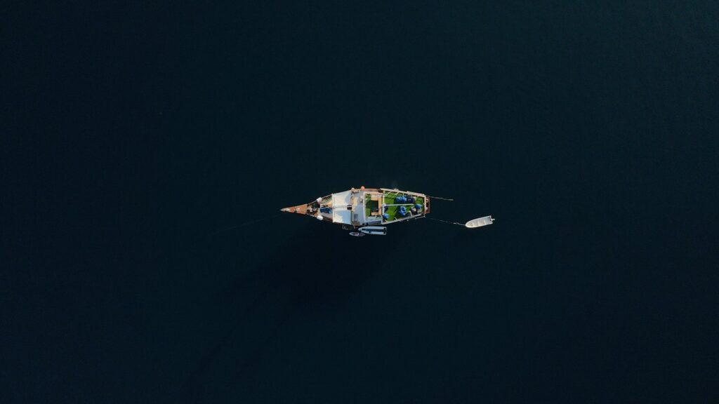 Aerial view of the Leticia anchored with its tender alongside dark water