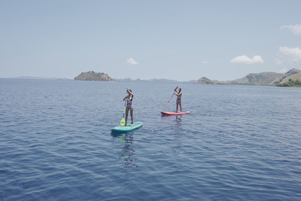 Two guests paddleboarding on calm water near Manjarite Island