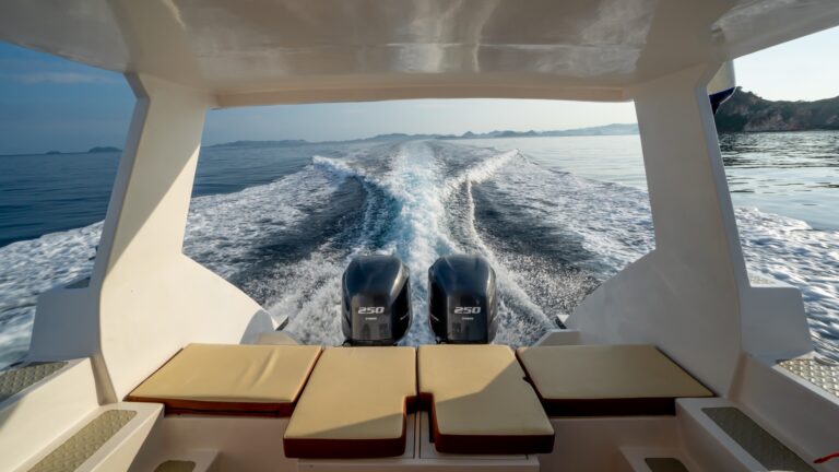 Aft deck of Ocean Queen with cushioned bench seating and twin engine wake