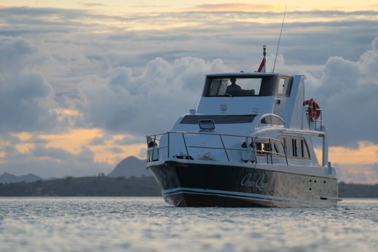 Ocean Queen labuan bajo speedboat at anchor under a dusky, cloud-streaked sky