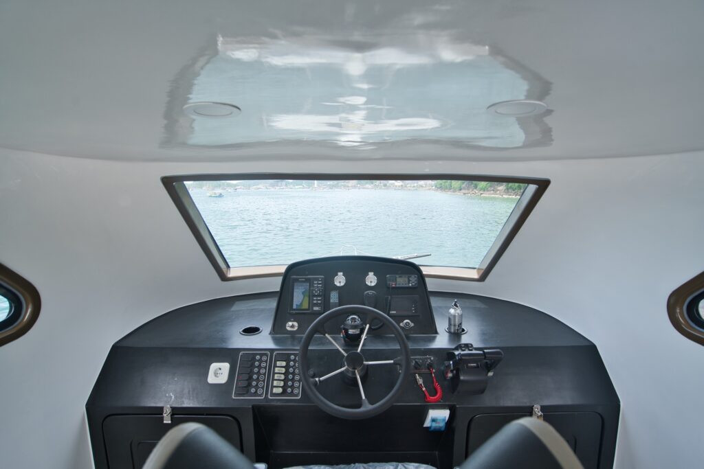 Speedboat helm with steering wheel, dashboard, and forward windshield view