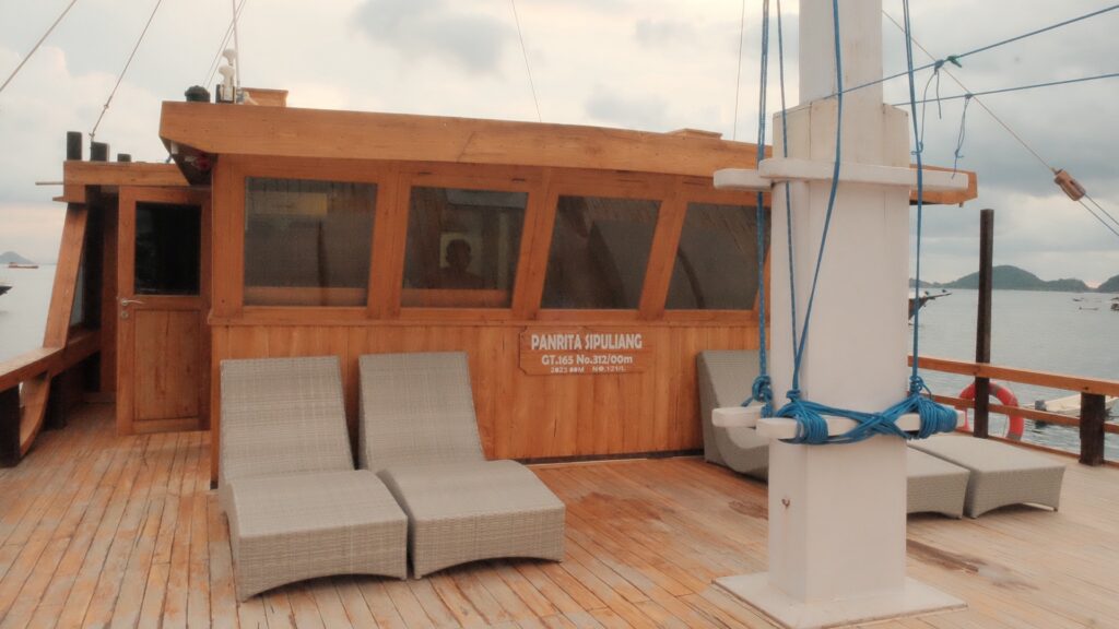 Grey wicker sun loungers on the open deck beside Panrita's wheelhouse