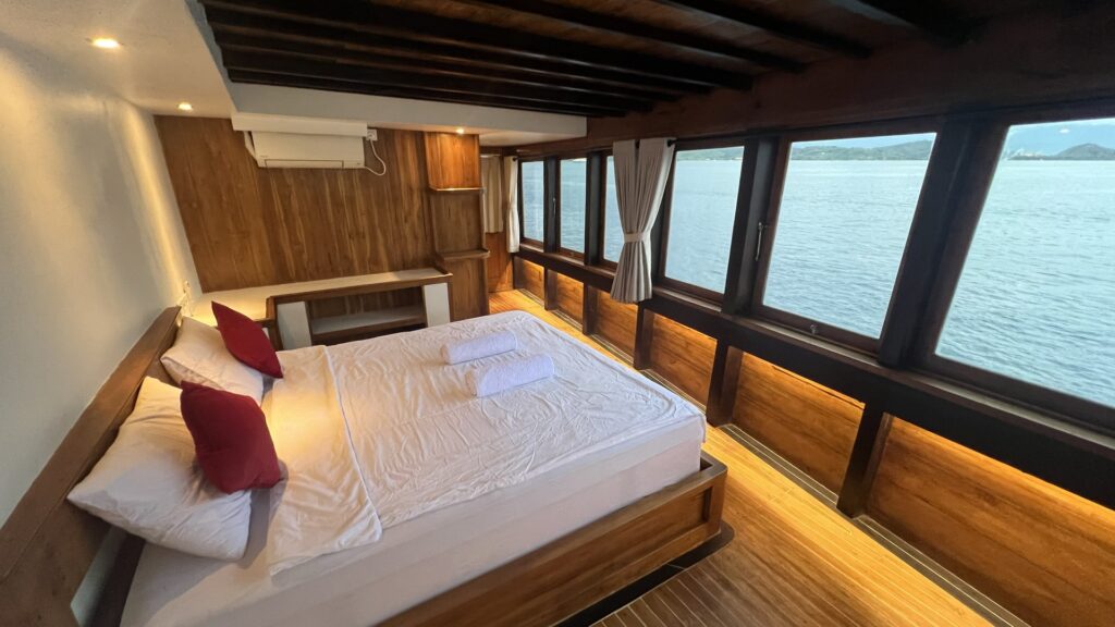 Panrita's window-lined suite with a large bed facing the open water