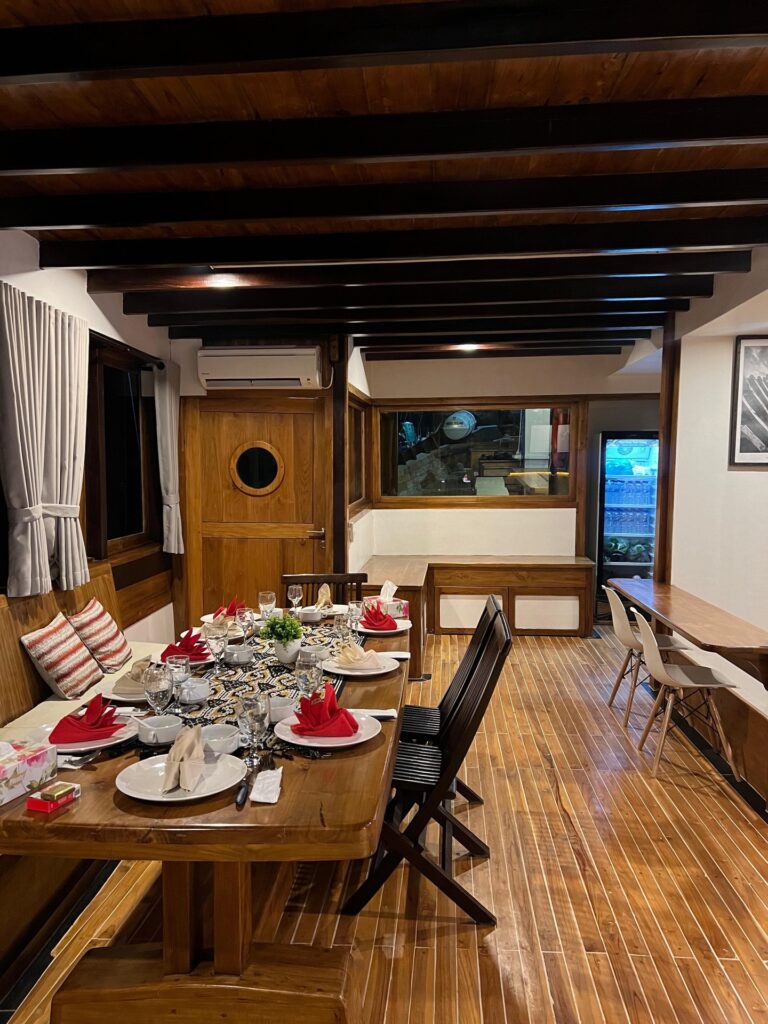Indoor dining salon on Panrita with a long table set for dinner
