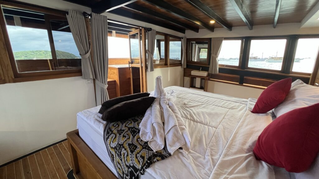 View from the bed toward curtained windows overlooking the water