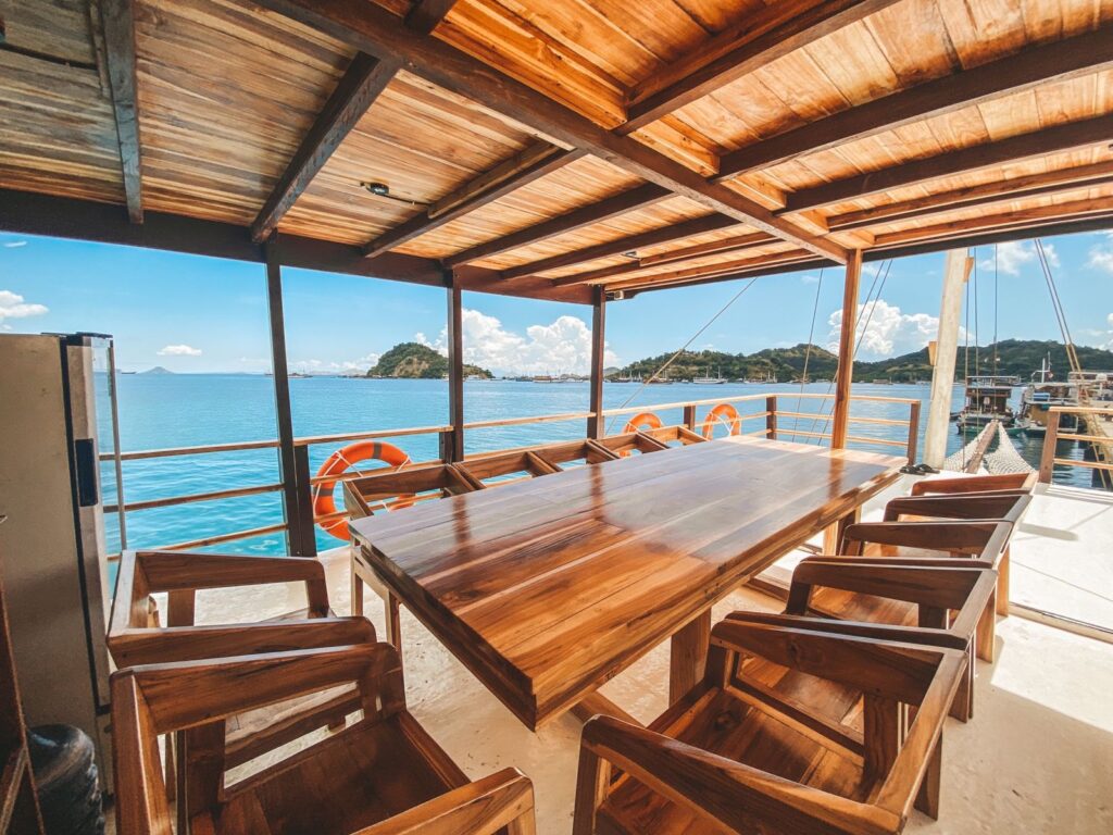 Papiton Duwa's covered dining deck with a long wooden table and ocean view