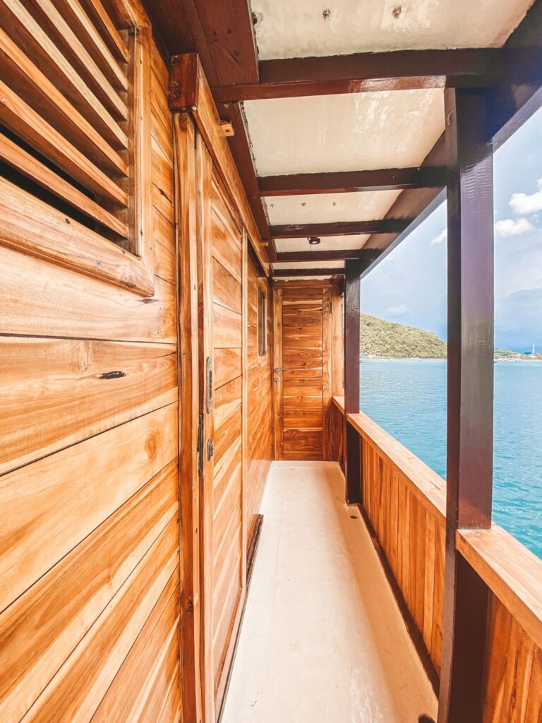 Covered wooden corridor along Papiton Duwa's deck with sliding doors and ocean views