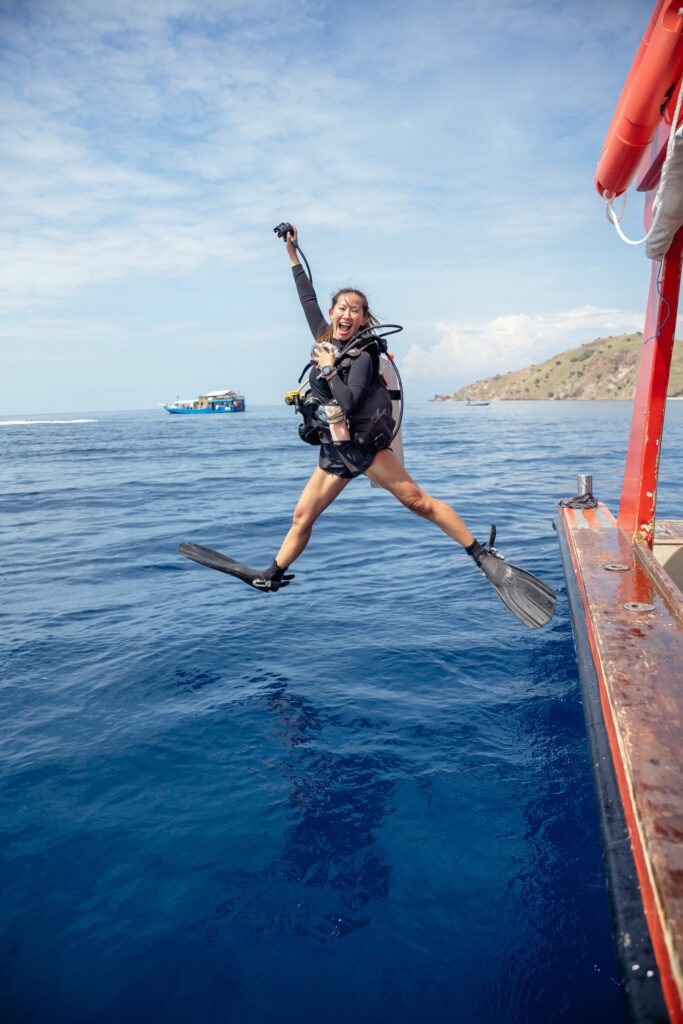 Diver making a giant stride entry off the side of Red Whale into the water