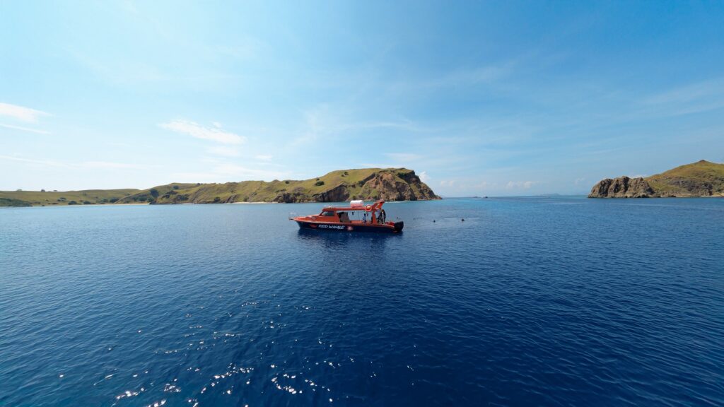 Red Whale anchored in a wide bay surrounded by hills