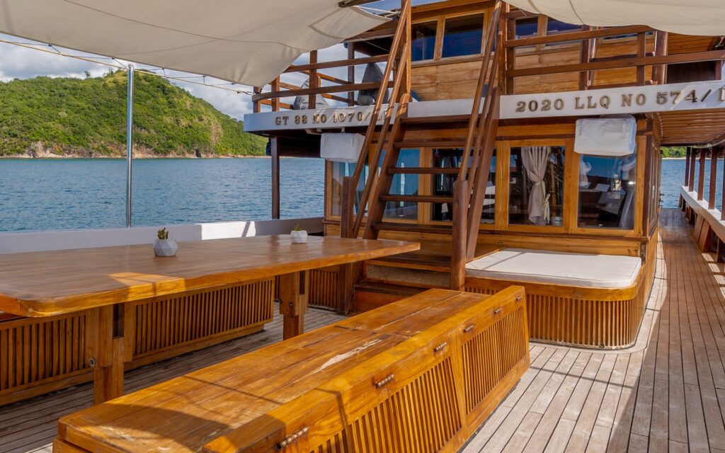 Refviero outdoor dining deck with a long wooden table under a shaded canopy