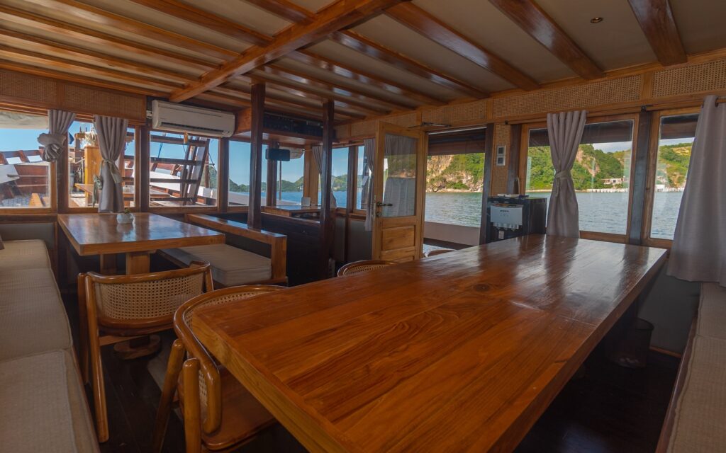 Indoor dining salon with long wooden tables and wrap-around cushioned bench seating