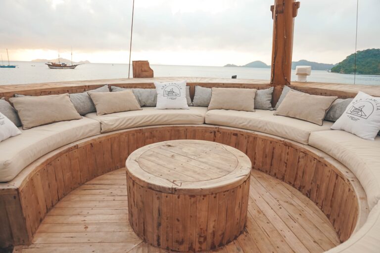 Sea Familia's curved wooden bench seating on the bow with cushions