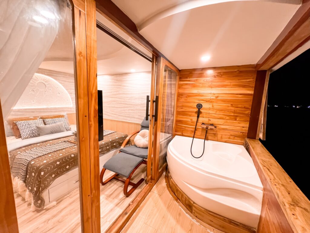 Earth Suite bedroom opening onto a private balcony with a wood-set tub at night