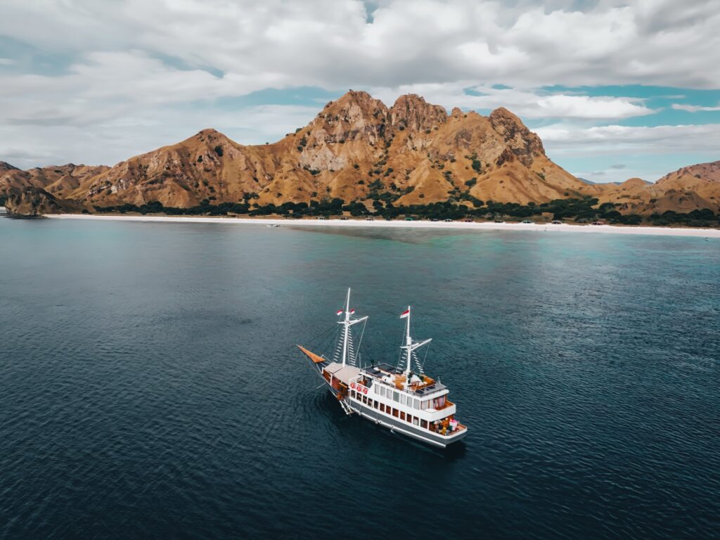 The Semesta Voyage Komodo liveaboard anchored in a turquoise bay near Pink Beach
