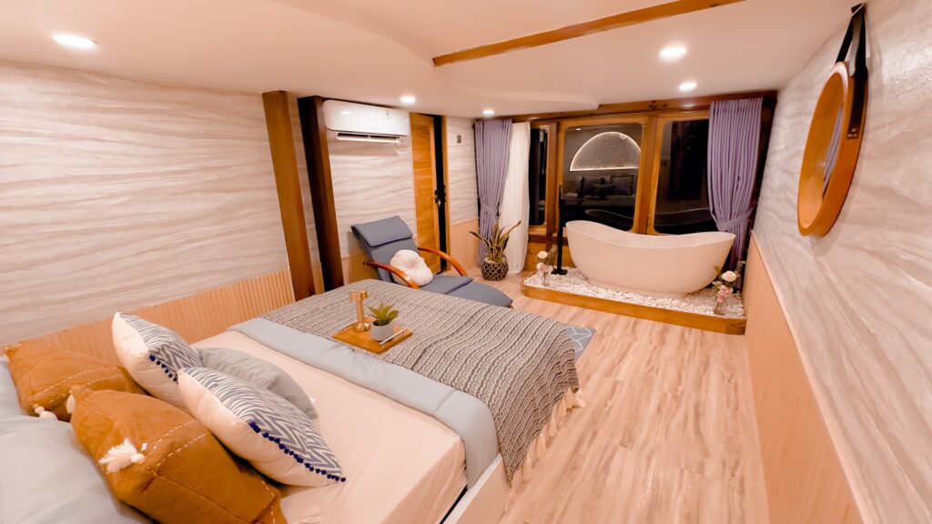 Mars Suite interior with a king bed, wooden armchair, and a corner bathtub in view
