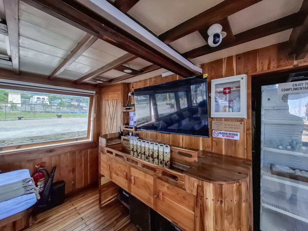 Soe Besar Vanrei's indoor lounge with a flat-screen TV, wood cabinetry and drinks fridge