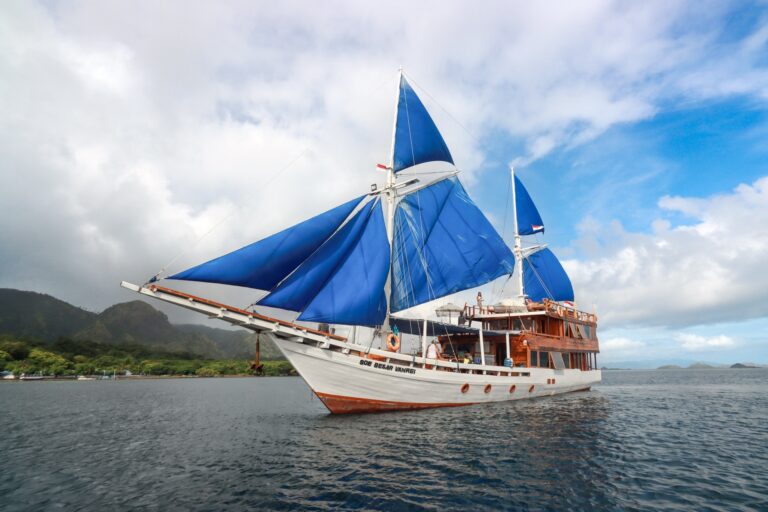 Soe Besar Vanrei komodo liveaboard under full sail with blue canvas billowing