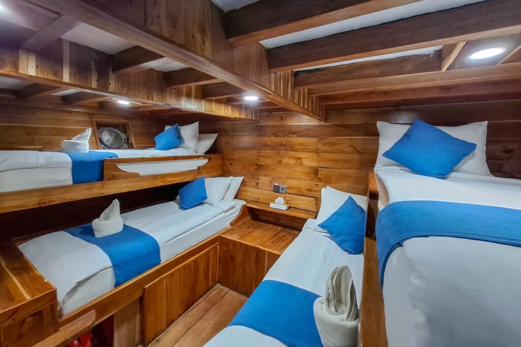 Symmetrical bunk beds in a quad cabin with a round porthole window