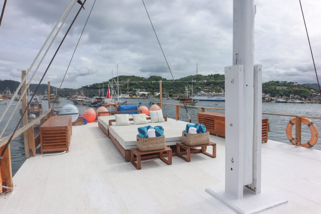 Soe Besar Vanrei's sun deck daybed with cushions overlooking a busy harbor