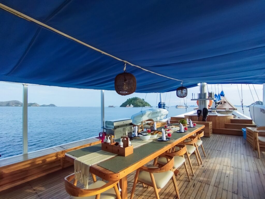 Soe Besar Vanrei's shaded deck dining table set for a group meal at sea