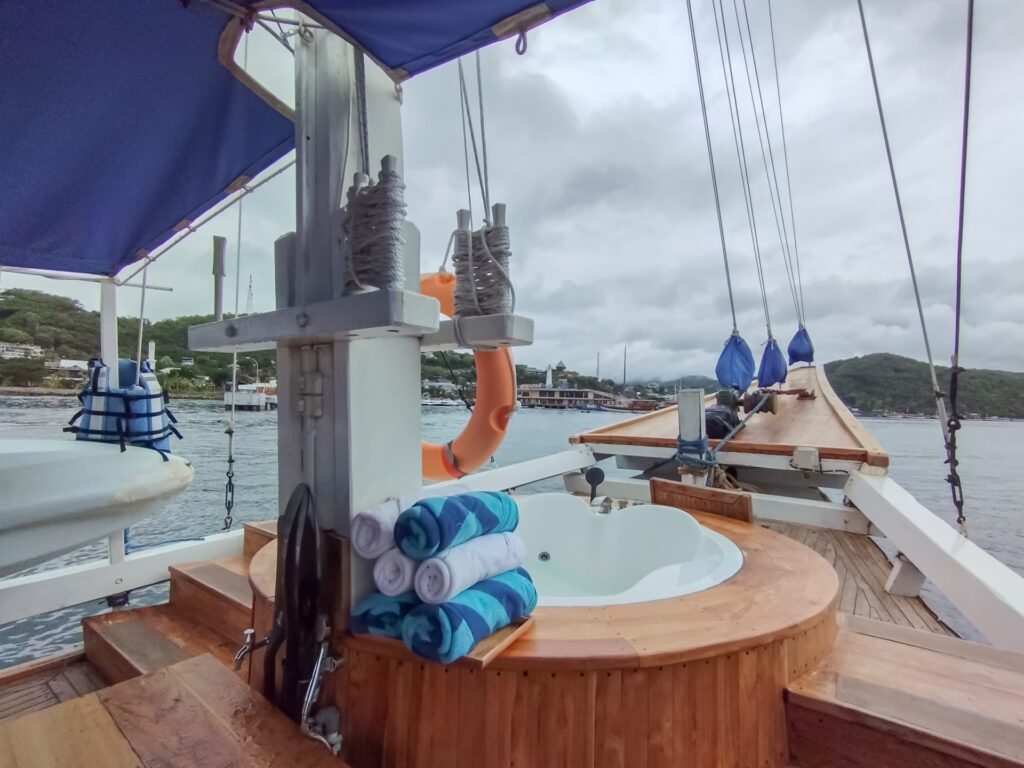 Bow jacuzzi with rolled towels and rigging, moored boats in the background
